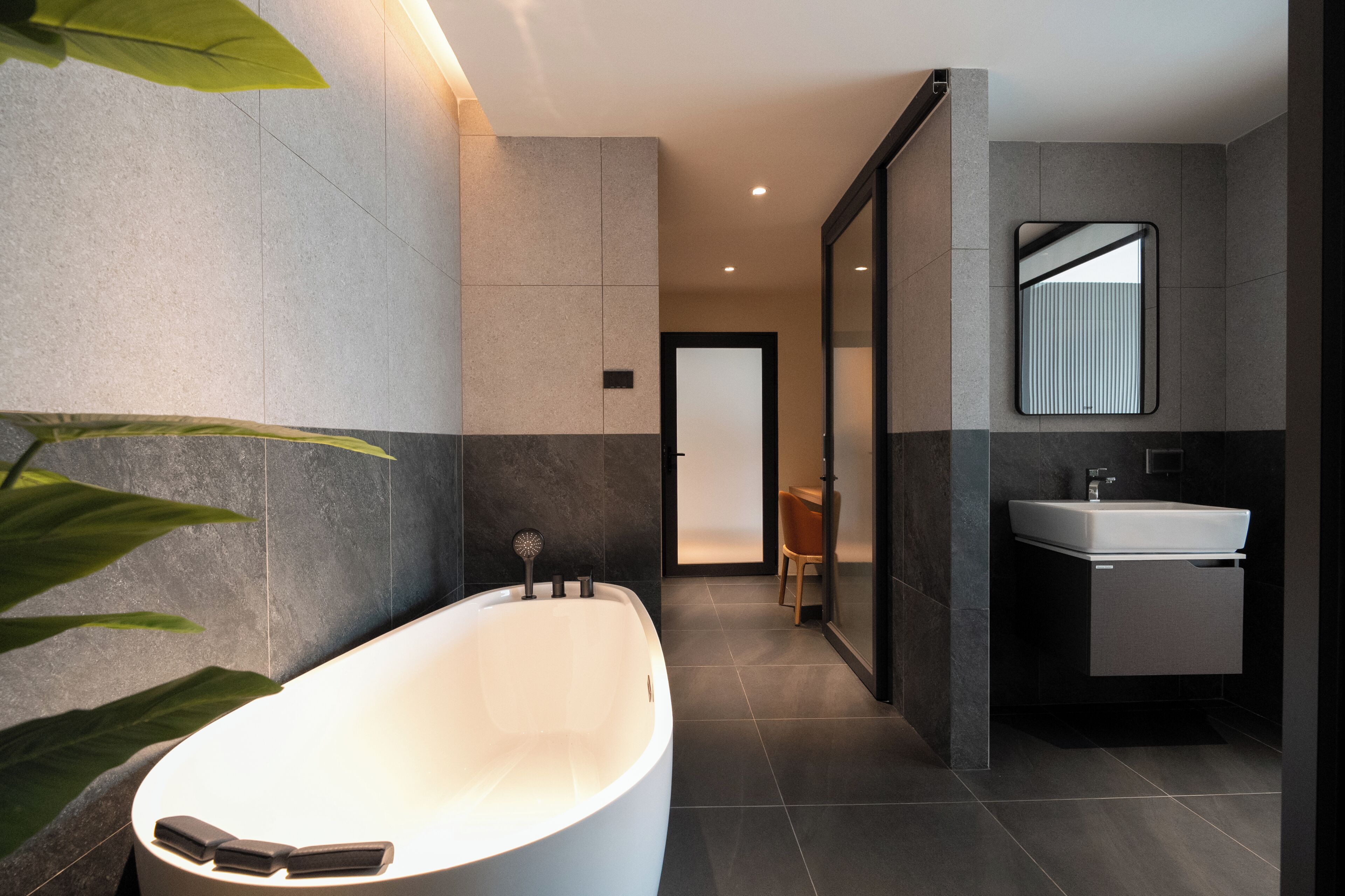 A modern bathroom with a freestanding bathtub, a mirror, and a sink.