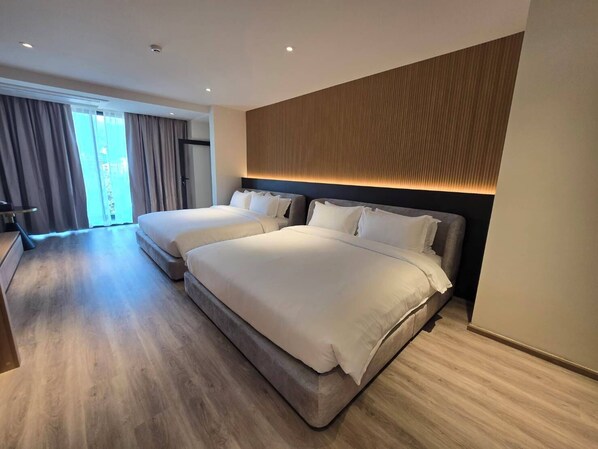 A modern hotel room with two beds, a large window with curtains, and a wooden accent wall. - The Clover Hotel (Chiang Mai)
