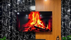 Una sala de estar moderna con un televisor de pantalla plana grande montado en una pared con diseño de mármol negro.