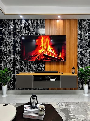 A modern living room with a large flat-screen TV mounted on a wall with a black marble pattern.