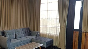 Un salon moderne avec un canapé d’angle et une table basse en bois.