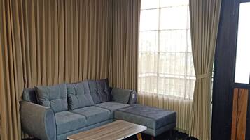 Una sala de estar moderna con un sofá modular y una mesa de centro de madera.