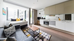 Eine moderne Wohnung mit Schlafzimmer, Wohnbereich und Küchenzeile.