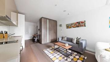 Um apartamento moderno com cozinha, sala de jantar, sofá e cama.