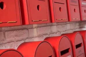 A row of red mailboxes against a brick wall. - H Boutique Hotel Sri Petaling (Kuala Lumpur)