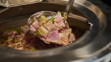 Alguien levanta una cucharada de comida de una cocedora lenta.
