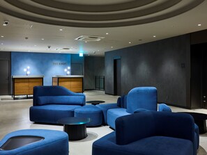 A modern lobby with blue seating, a reception desk, and a wall-mounted sign reading "THE KNOT". - THE KNOT UTSUNOMIYA (Utsunomiya)