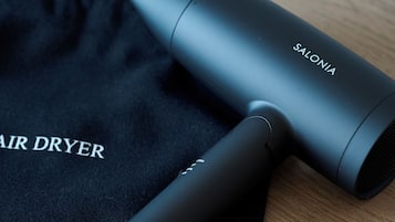 A black air dryer and a black bag with 'SALONIA' and 'AIR DRYER' text.