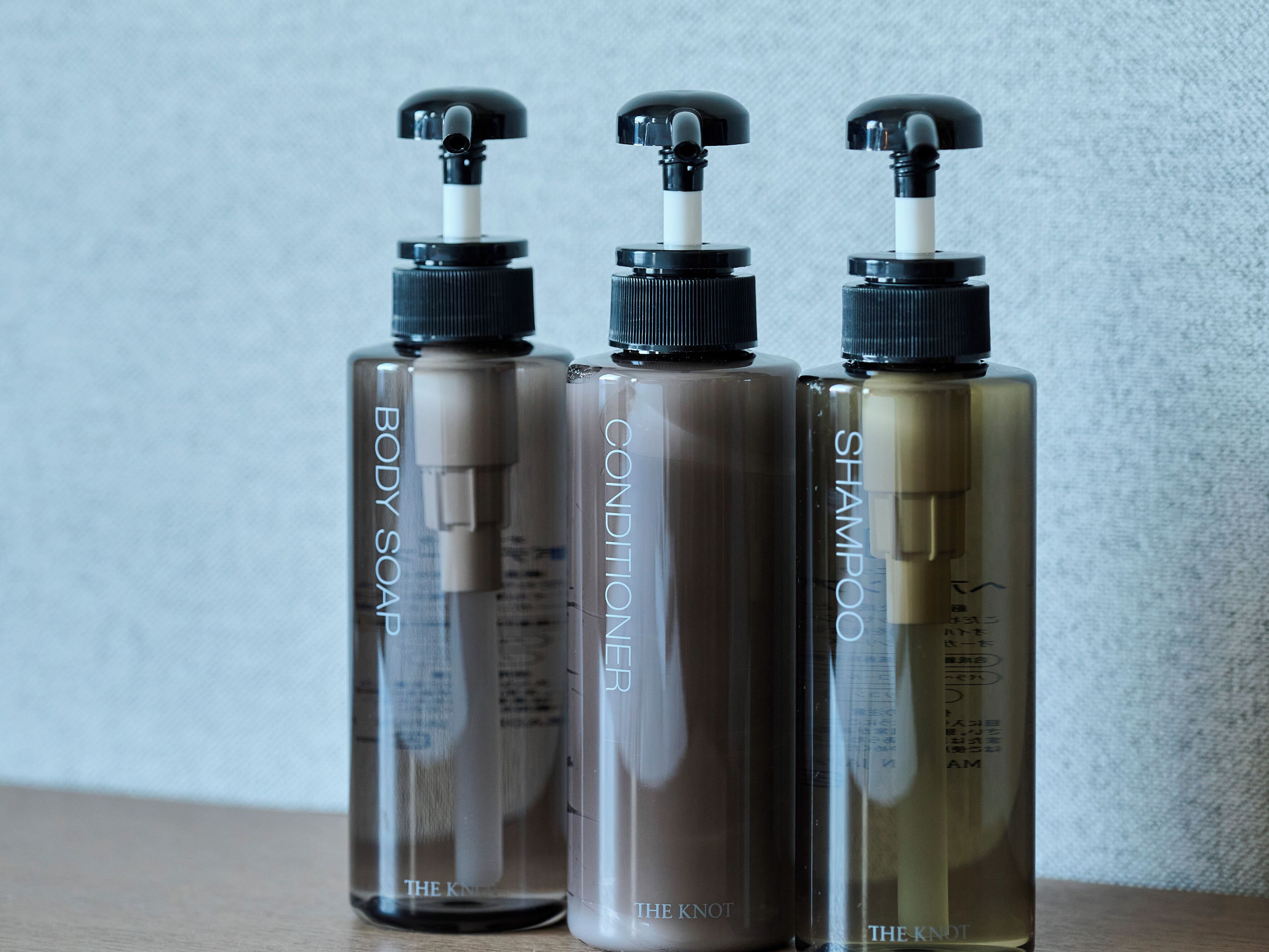 Three bottles of The Knot brand personal care products.
