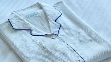 A neatly folded white shirt with blue trim and buttons.