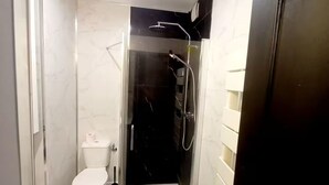 A bathroom with a toilet, a shower enclosure, and a sink. - Les suites du jardin 4 (Chaumont)