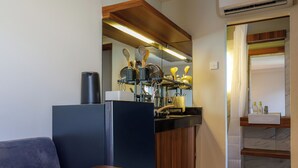 A compact kitchen with a built-in stove, a sink, and a countertop with various kitchen utensils. - Andewi Cabin (Mengwi)
