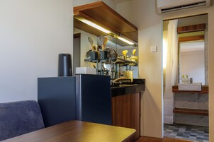 Cocina compacta con estufa integrada, un lavamanos y una encimera con diversos utensilios de cocina.