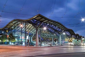 Una estación de tren moderna con techo curvo y fachada de vidrio, destacando un cartel grande que dice 'Southern Cross Station'.