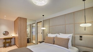Une chambre d’hôtel moderne avec un grand lit, des tables de chevet, un bureau et un miroir.