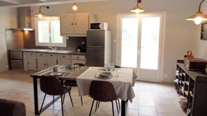 A modern kitchen with white cabinets, a built-in microwave, and a dining area with a table set for four.