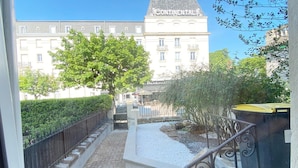 Un patio con un árbol, una zona de grava y un edificio con la leyenda 'Continental' al fondo.