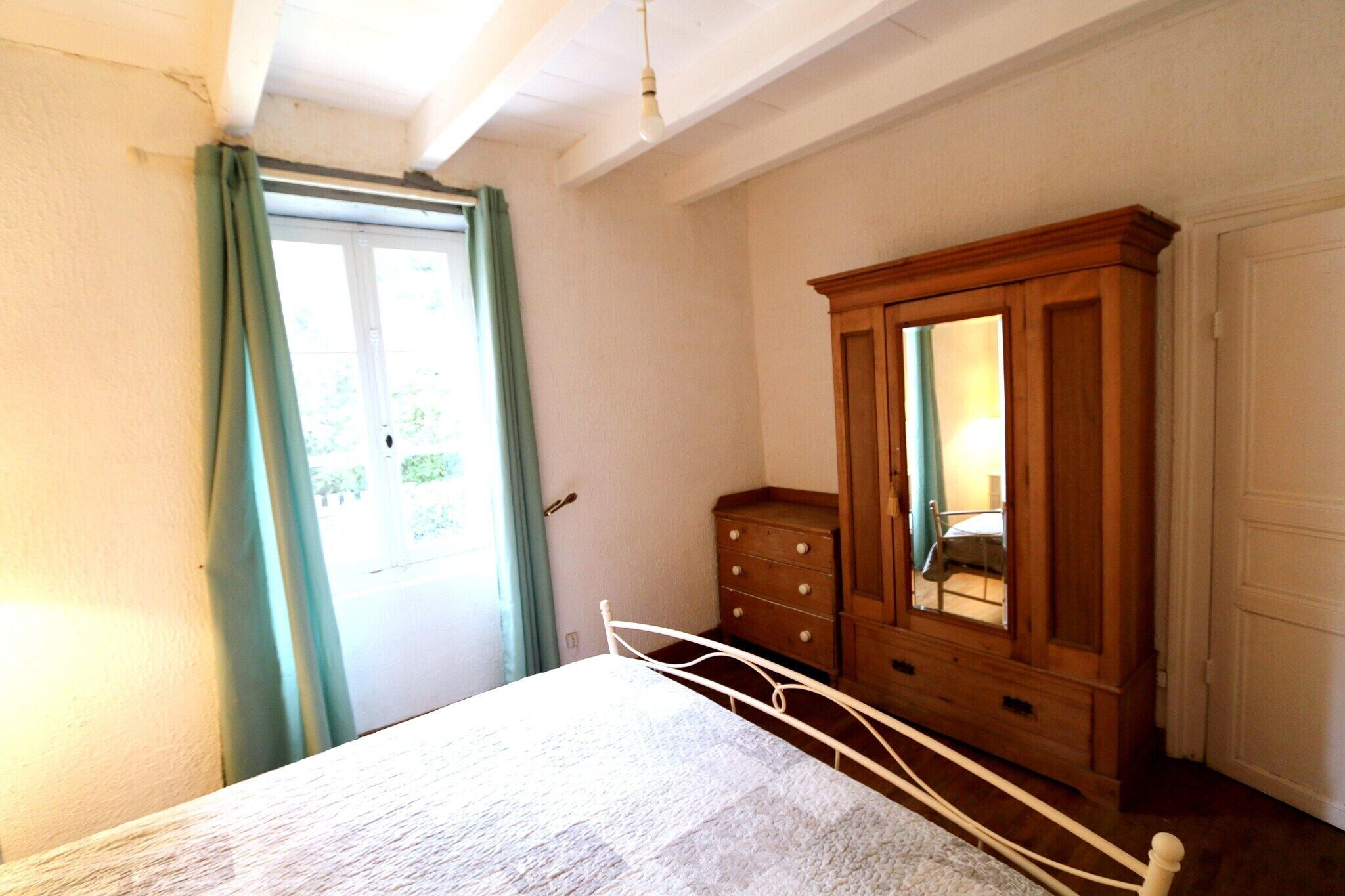 Un dormitorio con cama, cómoda de madera y espejo.