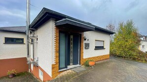 A modern house with a brick facade, a dark-colored door, and a small porch. - Holiday Home in Birresborn with balcony (Birresborn)