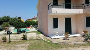 Un bâtiment à deux étages doté d’un balcon, d’une piscine et d’un espace extérieur aménagé pour s’asseoir.