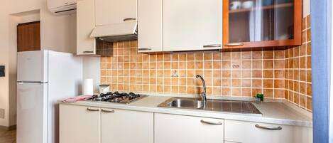 Geladeira, cooktop, cafeteira/chaleira, mesas de jantar