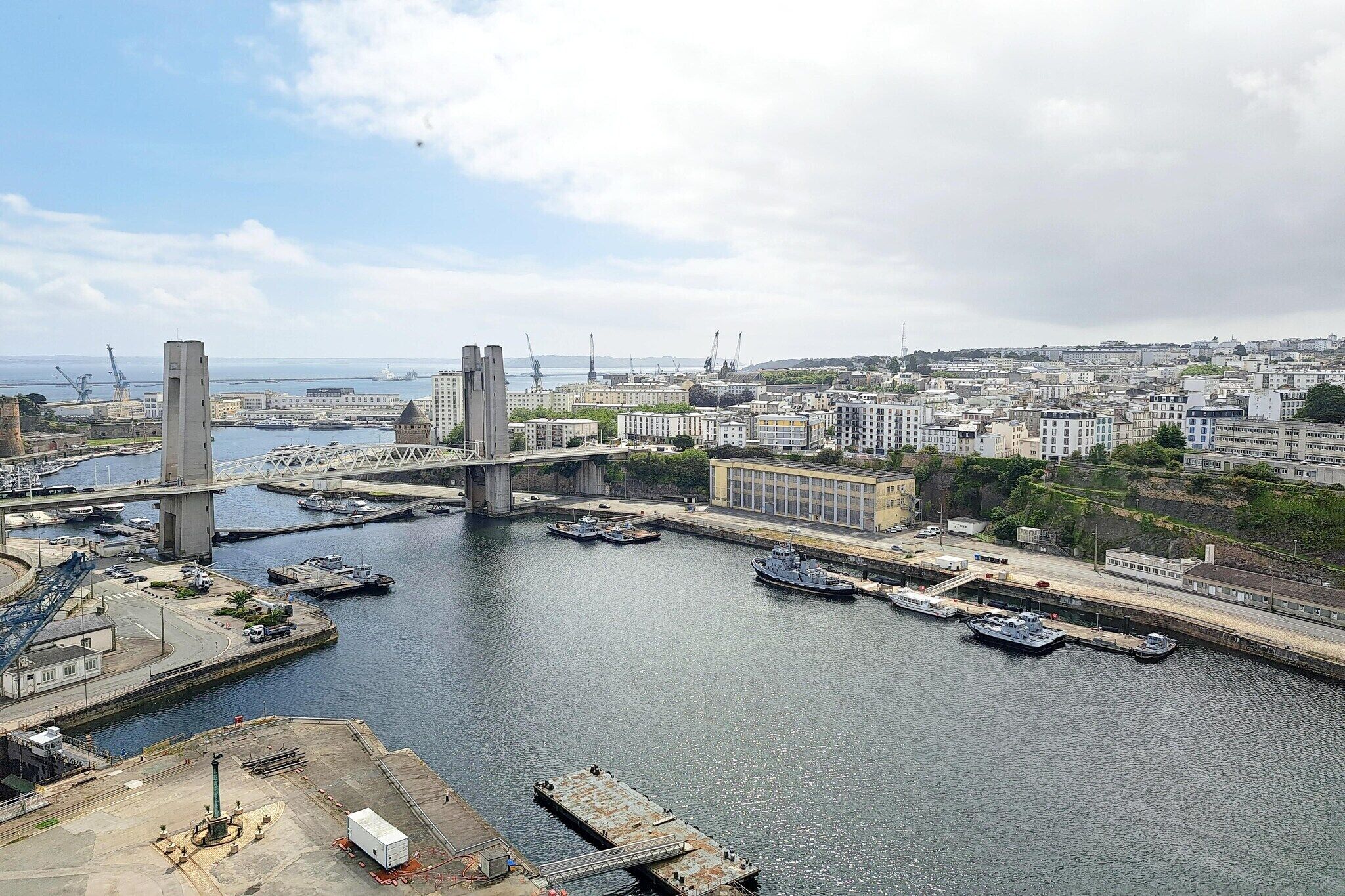 Un port avec un pont, des bateaux et une vue sur la ville en arrière-plan.