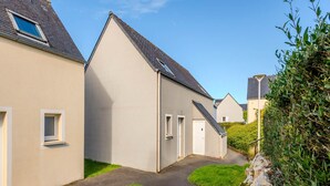Un immeuble résidentiel doté d’un toit en pente, d’une petite fenêtre et d’une porte.