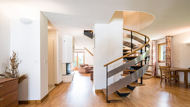 A modern interior with a spiral staircase, wooden flooring, and a dining area. - Bright family apartment with balcony (Giez)