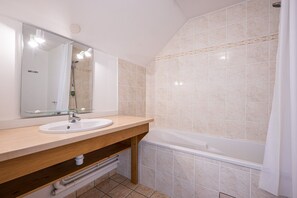 Ein Badezimmer mit Waschbecken, Spiegel, Dusche und Badewanne.