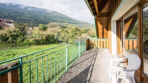 A balcony with a view of a green landscape and mountains. - Bright family apartment with balcony (Giez)