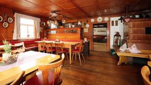 Een gezellig restaurant met houten meubels, een bar en uitzicht op de straat.