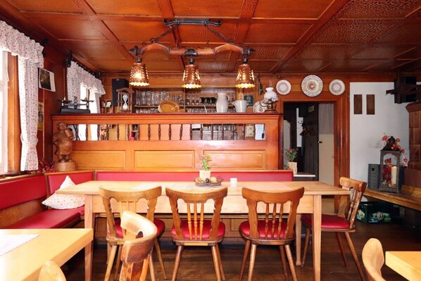 A traditional inn with wooden furniture, a bar area, and a cozy seating arrangement.