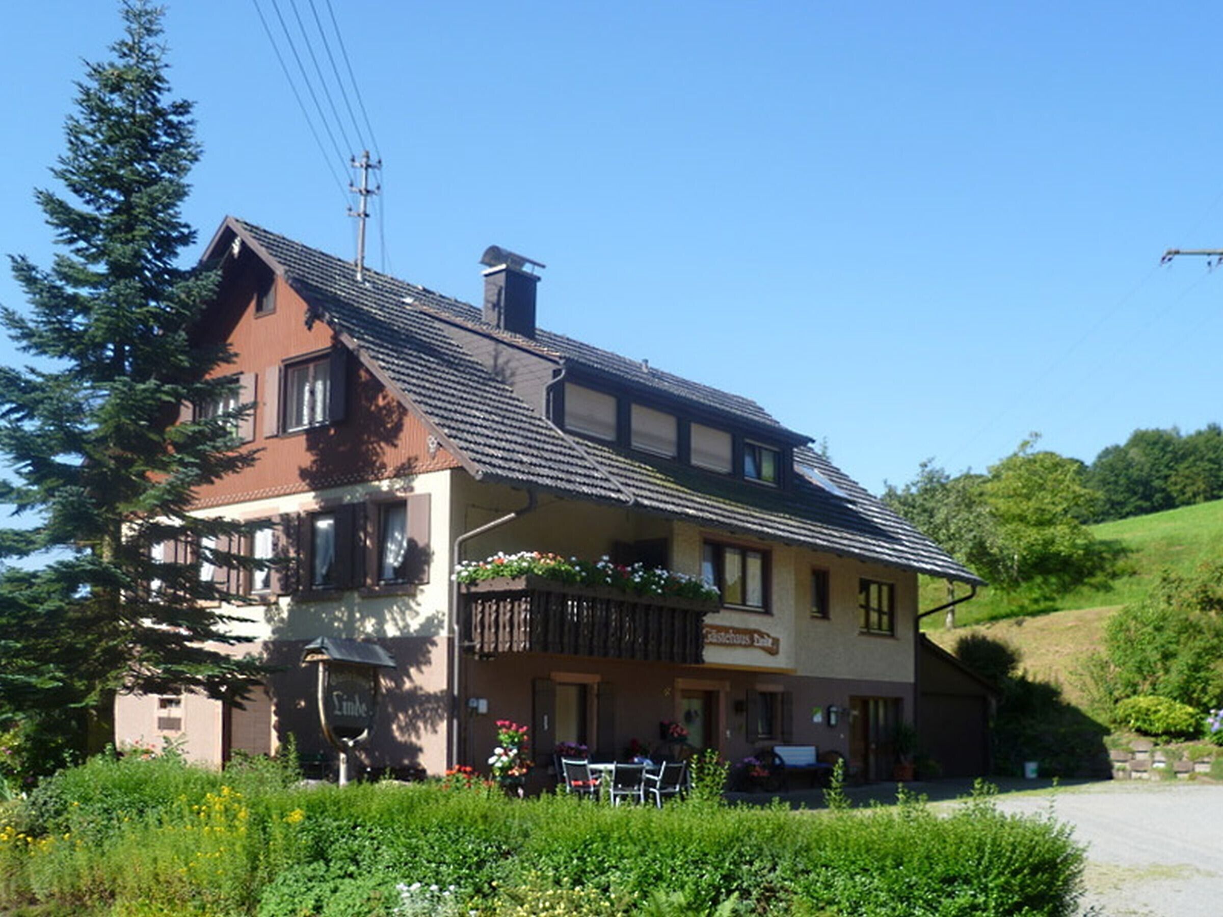 A two-story building with a balcony, a sign reading 'Gasthof,' and a car parked in front.