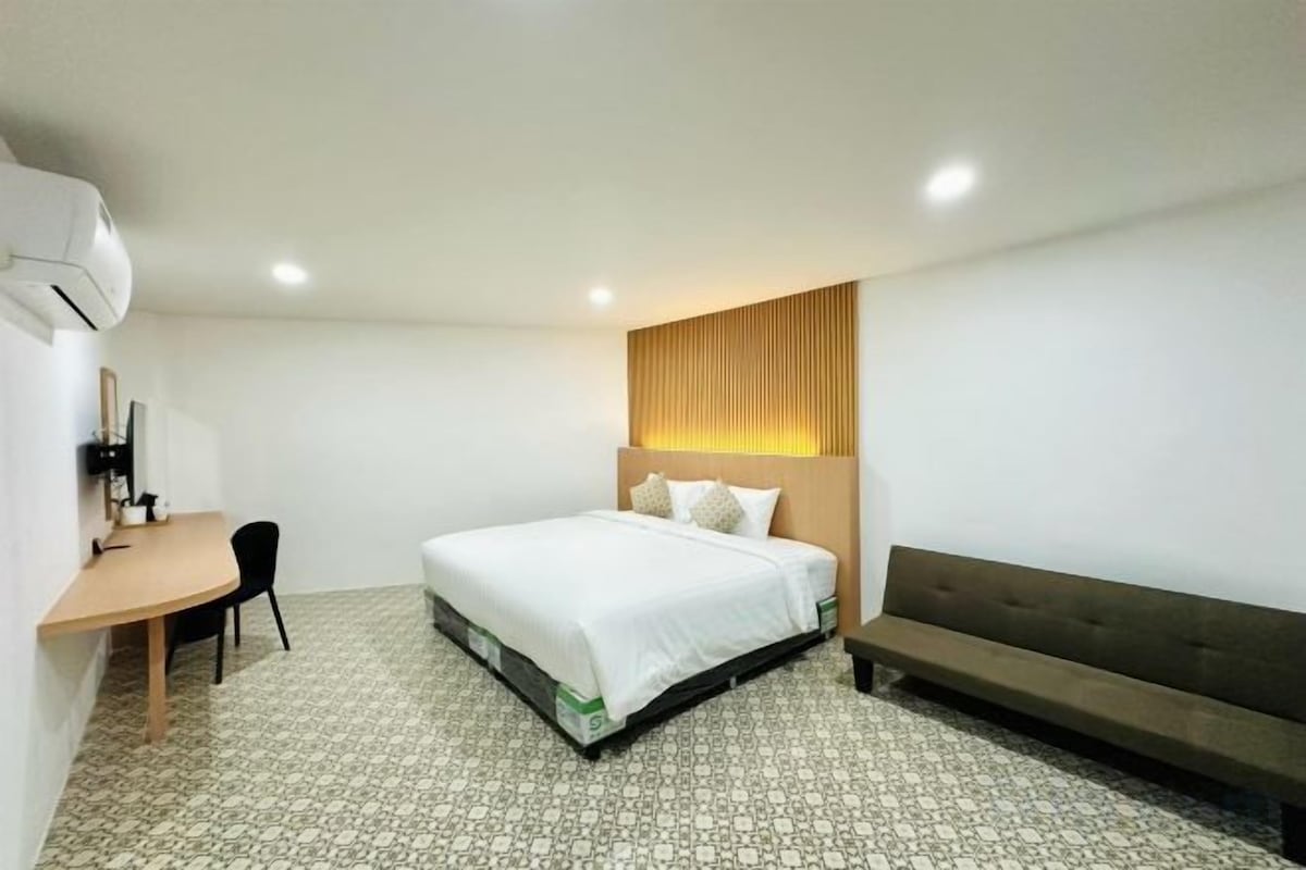 Una habitación de hotel con una cama, un escritorio y una silla.