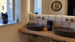 A bathroom with two vessel sinks, a window, and a mirror. - A stone's throw from the cathedral: authentic Sicilian house in Ortigia (Siracusa)