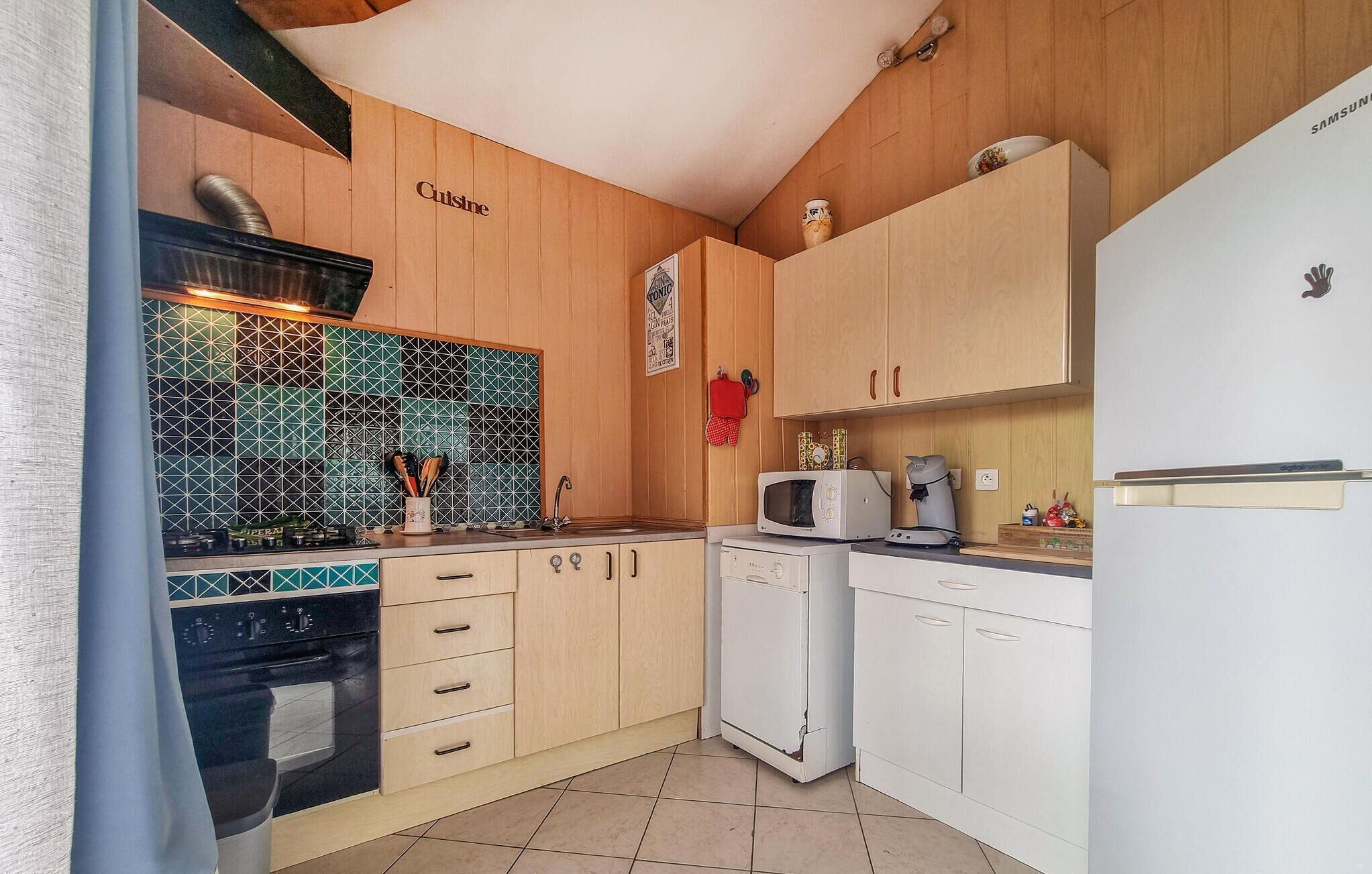 A compact kitchen with wooden cabinets, a microwave, a coffee maker, and a dishwasher.
