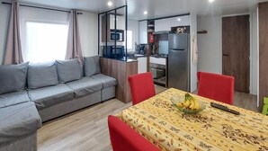 A compact living space with a sofa, dining table, and kitchenette.