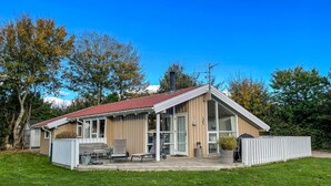 A single-story house with a red-tiled roof, a covered patio with outdoor furniture, and a fenced yard. - Pet friendly home in Humble with sauna (Humble)