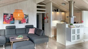 A modern living room with a grey sectional sofa, a small wooden coffee table, and a vibrant abstract painting. - Pet friendly home in Humble with sauna (Humble)