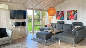 A modern living room with a sectional sofa, a flat-screen TV, a coffee table, and artwork on the walls. - Pet friendly home in Humble with sauna (Humble)