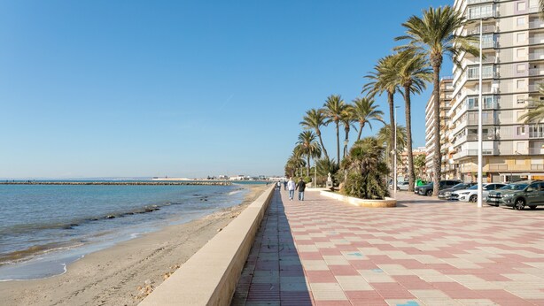 A coastal promenade with a checkered pavement, palm trees, and a building with balconies. - Apartment 'Mar 4 En Santa Pola' with Sea View, Private Terrace and Wi-Fi (Santa Pola)