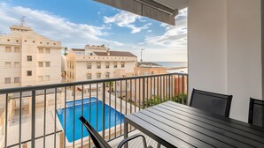 A balcony with a view of a swimming pool, a table, and chairs. - Apartment 'Mar 4 En Santa Pola' with Sea View, Private Terrace and Wi-Fi (Santa Pola)