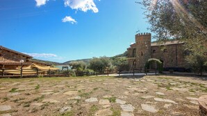 A courtyard with stone paving, a rustic building with a tower, and a view of a lake. - Awesome home in Cicerale (Cicerale)
