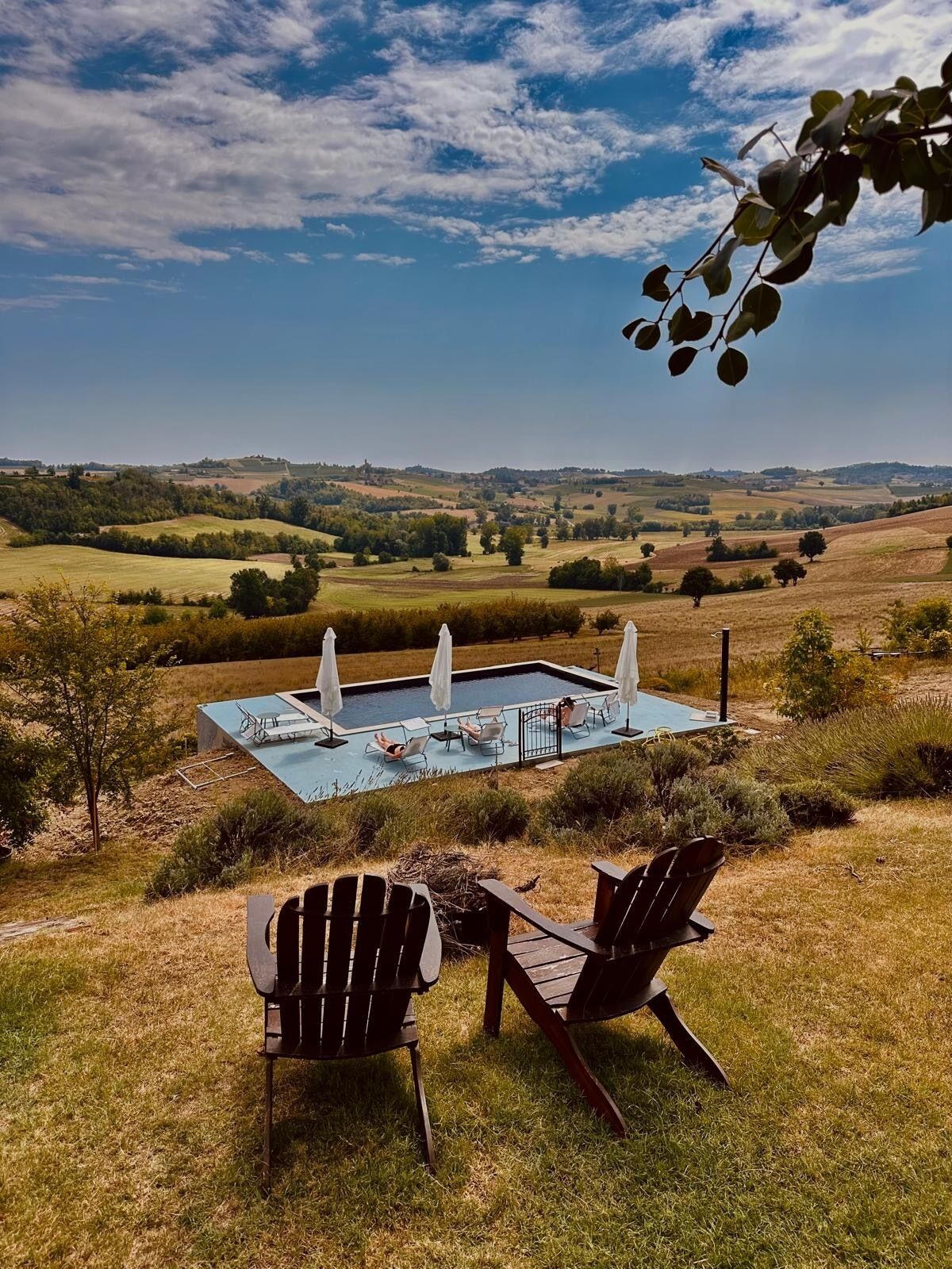 Area piscina con lettini prendisole e vista sulle dolci colline.