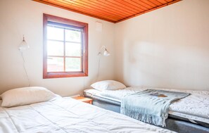 A room with two beds, a window, and a wooden ceiling. - Cozy home in Byxelkrok with WiFi (Byxelkrok)