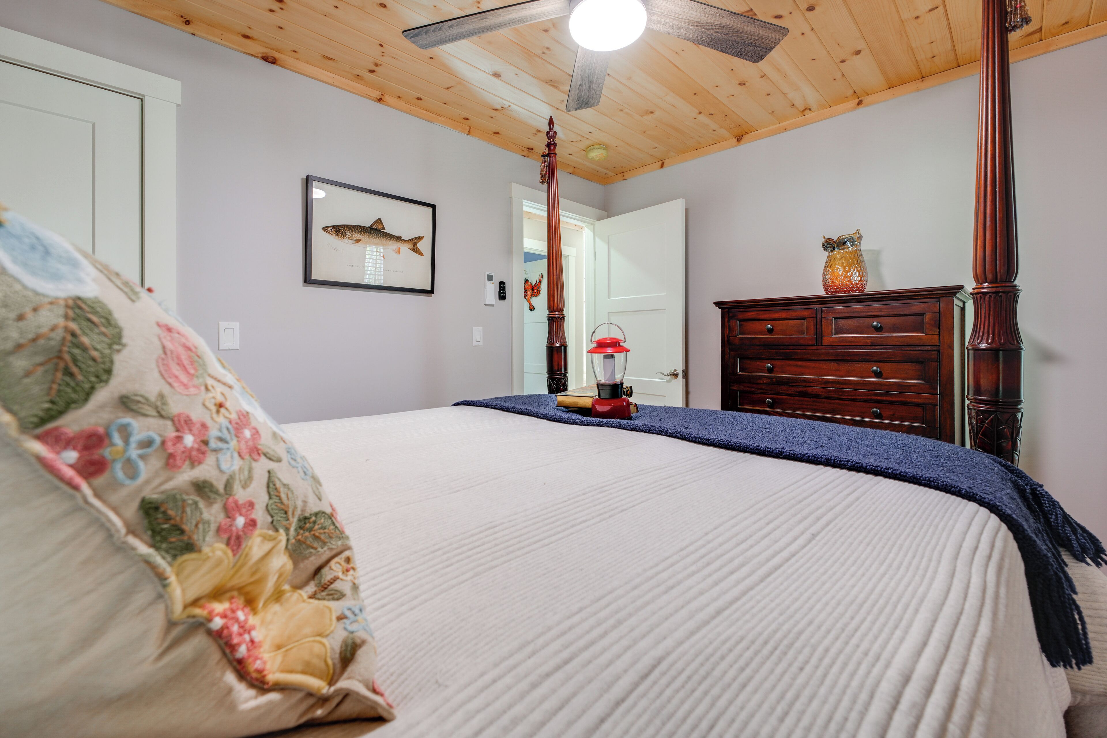 Ein Schlafzimmer mit einem Bett, einem Holzklimaanlage, einem Schminktisch und einem Wandbild mit Fischen.