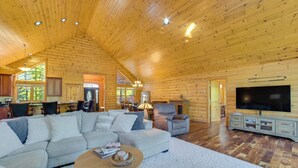 A spacious living room with a large sectional sofa, a television, and a fireplace. - Luxury Cabin in The Reserve at Boyne Mountain (Boyne City)