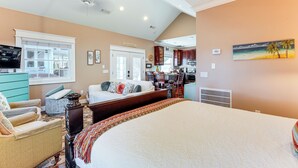 A spacious bedroom with a large bed, a sitting area with a chair and a small table, a kitchenette, and a dining area. - Heart of Historic Chickamauga! Chic Studio w/ Pool (Chickamauga)