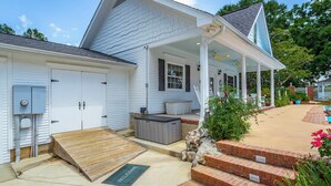 A white house with a covered porch, a small patio, and a wooden ramp leading to the entrance. - Heart of Historic Chickamauga! Chic Studio w/ Pool (Chickamauga)