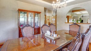 A dining area with a glass-top table, ornate chairs, and a chandelier. - 3 Mi to Sequoia Park Zoo: Spacious Home w/ Sunroom (Eureka)